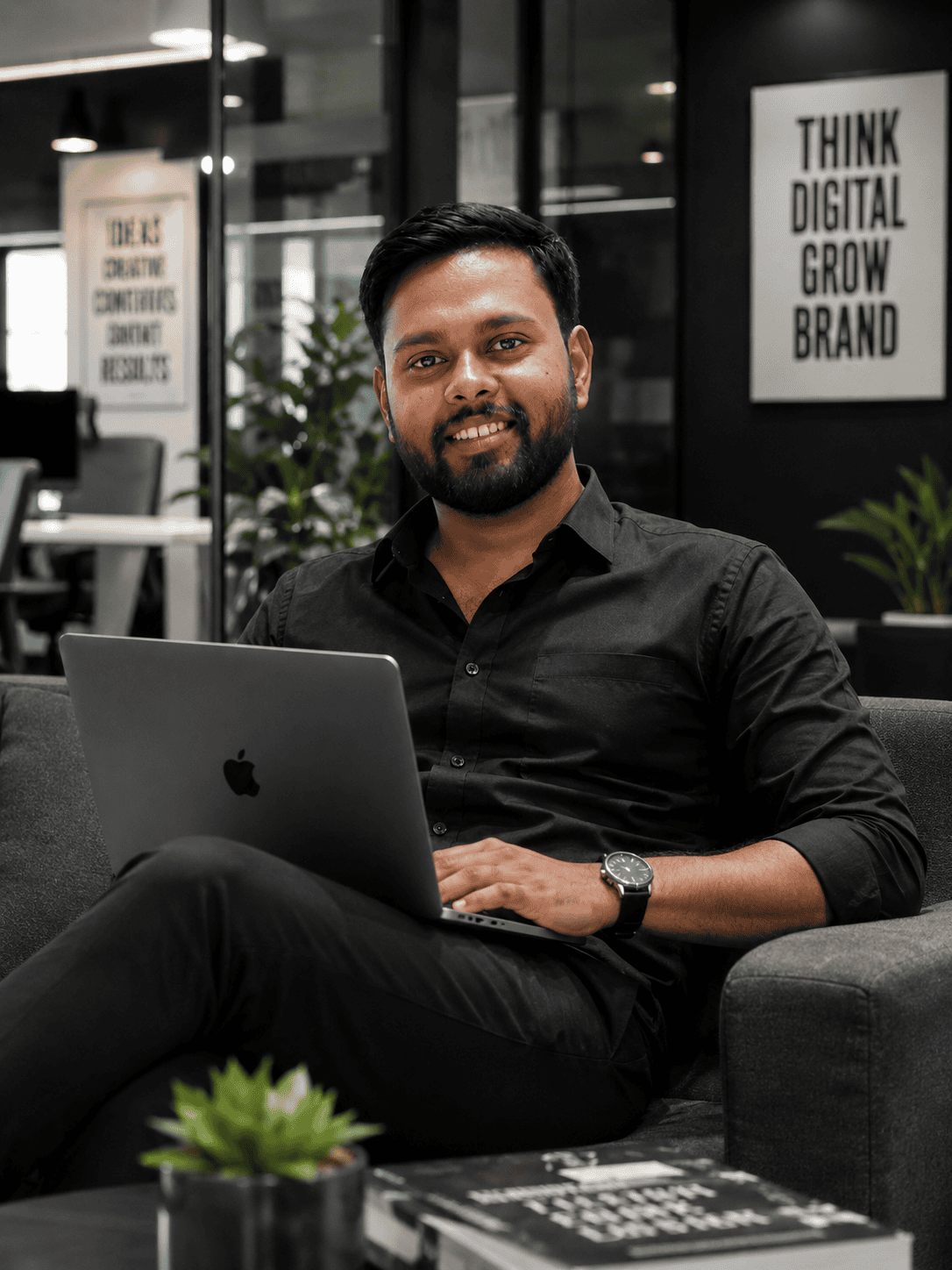 Professional man working on a laptop in a modern office setting.